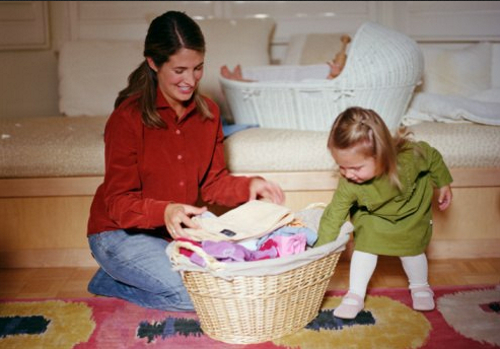 ребенок складывает игрушки в корзину